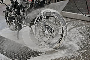 Motorcycle washing with cleaning foam. Pure moto bike. Enduro motorcycle. Cleanliness of vehicles. Car wash professional