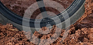 Motorcycle wheel on wet soil mud after raining in rainy season in countryside road