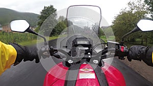 Motorcyclist on Bike Rides on a Landscape Mountain Road in the Rain