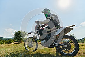 A motorcyclist equipped with professional gear, rides motocross on perilous meadows, training for an upcoming