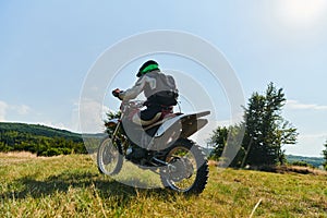 A motorcyclist equipped with professional gear, rides motocross on perilous meadows, training for an upcoming