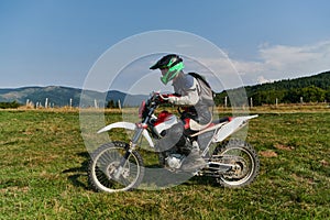 A motorcyclist equipped with professional gear, rides motocross on perilous meadows, training for an upcoming