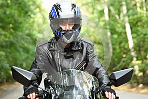 Motorcyclist goes on road, front view, closeup