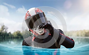 Motorcyclist in helmet and full gear awash. Man is half underwater