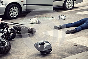 Motorcyclist helmet and motorbike on the street after collision