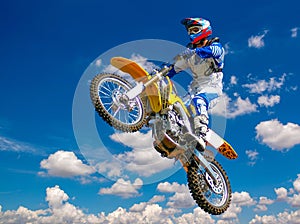 Motorcyclist jumping through sky, while racing.