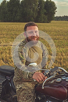 Motorcyclist racing his motorcycle down straight country road going a high speed at sunset