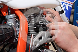 Motorcyclist replaces, checks the glow plug in a motorcycle