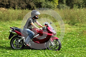 Motorcyclist riding on meadow