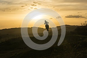 Motorcyclist riding off road during sunset. Slovakia