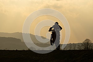 Motorcyclist riding off road during sunset. Slovakia