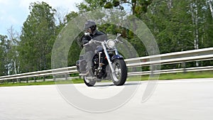 Motorcyclist on the road and trees on the roadside