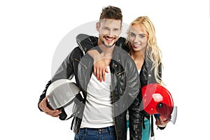 Motorcyclists couple with helmets in hand