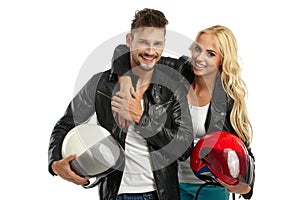 Motorcyclists couple with helmets in hand