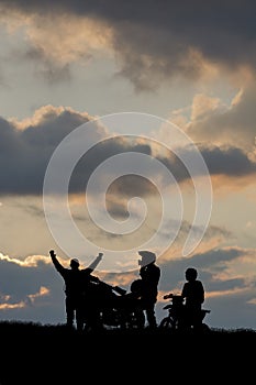 Motorcyclists on a mountain range during sunset