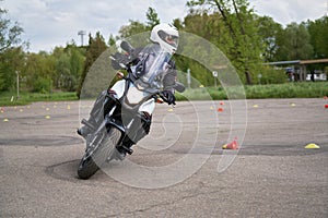 Motorcyclists ride through cones. Exersice for beginners and experienced. Free skill training as gymkhana for all people photo