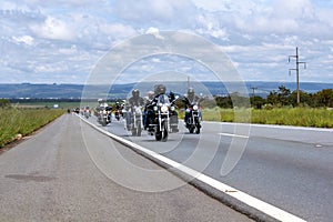 motorcyclists riding in convoy along the road photo