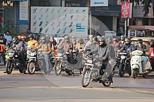 Motorcyclists stand at red traffic lights in India