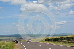 Motorcyclists tourists on the road in the steppes of Khakassia.