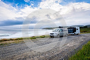 Motorhome RV and campervan are parked on a beach