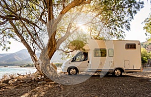 Motorhome RV parked on the beach under a tree facing the sea, Crete, Greece