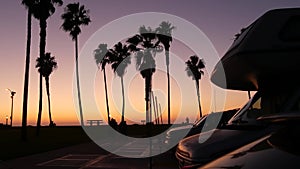 Motorhome trailer, caravan for road trip, palm trees, California beach at sunset