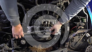 A motorist tightens the bolts on the head of a diesel engine using a torque wrench.