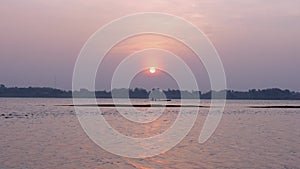 Motorized fishing boat going down the river at sunrise