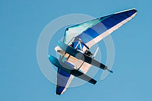 Motorized Hang Glider Flying On Blue Clear Sunny Sky Background