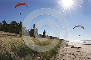 Motorized Hang Glider Kites Flying Over Secluded Beach photo