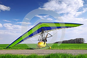 Motorized hang glider over green grass