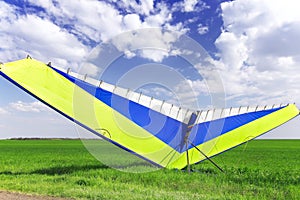 Motorized hang glider over green grass