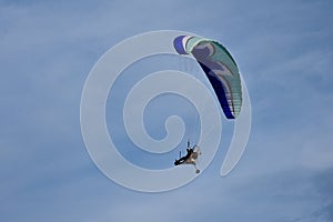 Motorized hang glider soaring in the blue sky