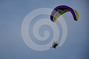 Motorized hang glider soaring in the blue sky