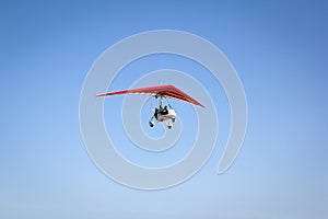 Motorized hang glider soaring in the blue sky