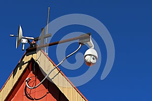 Motorized security camera with wireless transmission dish installed on christian mortuary chapel roof.