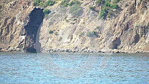 A motorized surfboard with a rider moving on a calm sea. The silhouette of a man on a water scooter glides through the