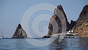 A motorized surfboard with a rider moving on a calm sea. The silhouette of a man on a water scooter glides through the