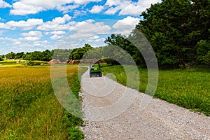 Motorized vehicle on gravel dirt road or path through a park on a beautiful bay.