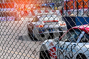 Motorsport car racing on asphalt road. View from the fence mesh netting on blurred car on racetrack background. Super racing car