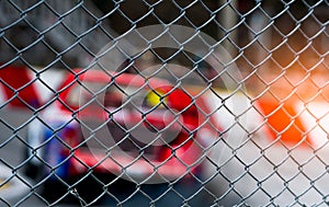 Motorsport car racing on asphalt road. View from the fence mesh netting on blurred car on racetrack background. Super racing car