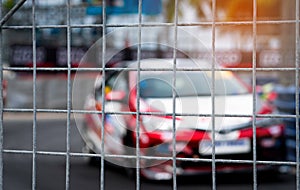 Motorsport car racing on asphalt road. View from the fence mesh netting on blurred car on racetrack background. Super racing car