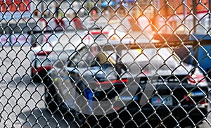 Motorsport car racing on asphalt road. View from the fence mesh netting on blurred car on racetrack background. Super racing car