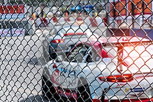 Motorsport car racing on asphalt road. View from the fence mesh netting on blurred car on racetrack background. Super racing car