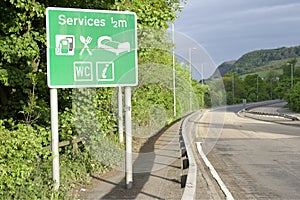 Motorway services sign countryside rural area WC toilets fuel petrol mall shops rest break time for tired drivers