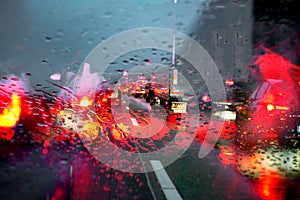 Motorway traffic jam caused by an accident on a wet road. View through a rainy windscreen to the roadway