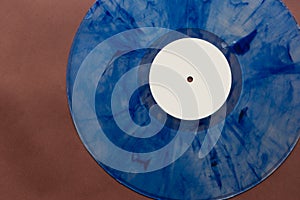 A mottled blue vinyl record with a white centre sticker