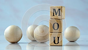 MOU- acronym on wooden cubes on the background of light balls