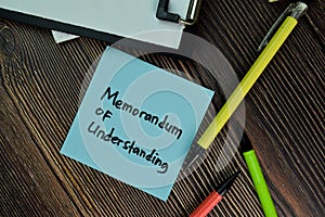 MOU - Memorandum of Understanding write on sticky notes isolated on Wooden Table. Business of Finacial concept