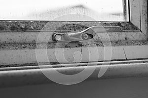 Mould, mildew and condensation on white plastic pvc window frame and glass